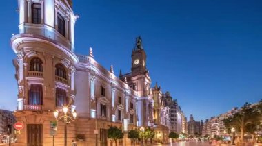 Valencia Belediyesi Ajuntament de Valencia Plaza de Ayuntamiento 'da günden geceye geçiş süreleri aşırı hızlanıyor. Saat kulesi olan tarihi bir bina. İspanya 'nın ana meydanında gezinen insanlar