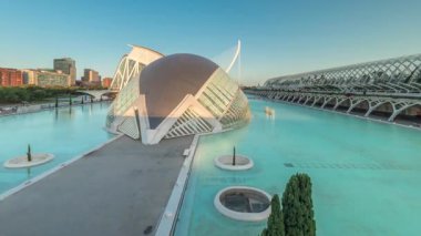 Valencias Sanat ve Bilim Şehri 'nin çarpıcı zamansal hızlandırılmış gölgelerinin fütüristik mimarinin üzerinde hareket etmesi sakin suya yansıyor. Günbatımında büyüleyici İspanyol kültürel simgesi