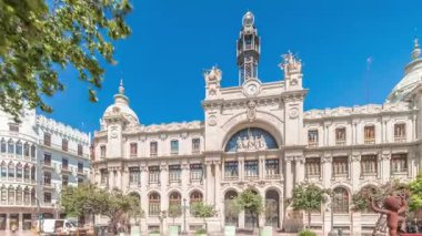 Panorama, Valensiya 'daki tarihi Postane Palau de les Comunicacions' ı gösteriyor. Şehir Meydanı Plaza del Ayuntamiento 'da. Süslü cephe, trafik ve İspanya şehir merkezinde mavi bir gökyüzü..