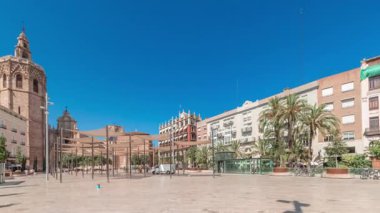 Panorama, İspanya, Valencia 'daki Plaza de la Reina' nın zaman çizelgesini gösteriyor. Tarihi bir kilise kulesi, hareketli kafeler ve sıcak Akdeniz mavi gökyüzünün altında merkezi bir çeşmesi olan canlı bir meydan..