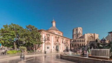 Valencias Plaza de la Virgen 'in zaman çizelgesini gösteren panorama, mavi gökyüzü altında Turia Fountain, Cathedral ve Virgen de la Virgen de los Desamparados' u sergiliyor.