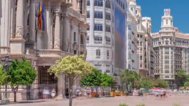 Valencia Belediye Binası Ajuntament de Valencia zaman kaplaması Plaza de Ayuntamiento 'da. Mavi gökyüzünün altındaki tarihi bina giriş kulesi. İspanya 'nın ana meydanında gezinen insanlar