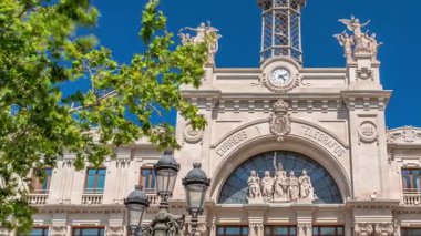 Valensiya 'daki tarihi posta ofisi Palau de les Comunicacions Belediye Meydanı Plaza del Ayuntamiento' da. Süslü cephe, yeşil ağaçlar ve İspanya şehir merkezinde mavi bir gökyüzü..