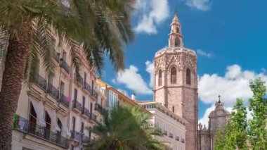 Valencia, İspanya 'daki Plaza de la Reina' nın panoramik zaman çizelgesi. Tarihi bir kilise kulesi, hareketli kafeler ve sıcak Akdeniz bulutlu gökyüzünün altında merkezi bir çeşme..