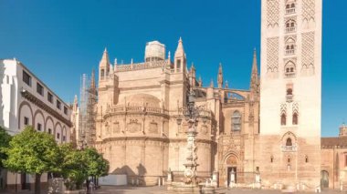 Seville Katedrali ve Giralda Kulesi 'nin Sevilla, İspanya' daki aşırı hızını gösteren panorama. Dünyanın en büyük gotik katedrali Virgen de los Reyes meydanında, mavi gökyüzünün altında.