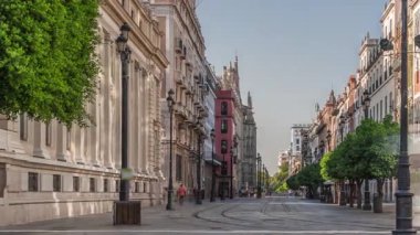 Avda boyunca yürüyen yayalar. De la Constitucion, Seville, İspanya 'nın Casco Antiguo bölgesindeki ana cadde. Edificio de la Adriatica yakınlarındaki zaman dilimi, tarihi binalar ve geçen tramvaylar