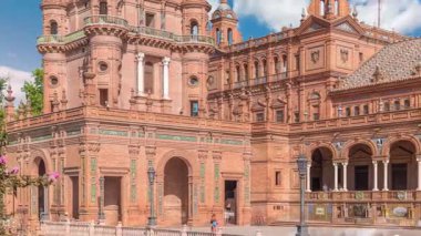 Seville Timelapse 'deki Plaza de Espana, Ibero-American Exposition için inşa edilen Maria Luisa Park' taki büyük bir mimari kompleks. Mavi bulutlu gökyüzünün altında kemerler, kanallar ve kırmızı duvarlar.