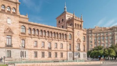Panorama, İspanya, Valladolid Plaza de Zorrilla 'da Süvari Akademisi zaman çizelgesi gösteriyor. Karmaşık mimarisi olan tarihi askeri bina, mavi bulutlu gökyüzünün altında kalabalık şehir manzaralarıyla çevrili.