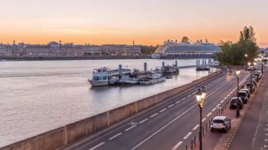 Gemi ve tekneler Fransa 'nın Bordeaux kentindeki Garonne Nehri boyunca iskeleye yanaştı. Günbegün deniz manzaralı geçiş zamanları, caddelerde trafik ve tarihi mimari