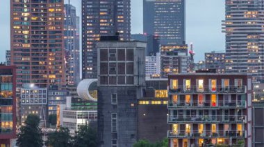 Rotterdam, Hollanda 'daki Katendrecht yarımadası ve Maashaven limanının hava ve gece geçiş zamanı. Günbatımından sonra parlayan pencereleri olan modern gökdelenler.