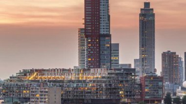 Rotterdam, Hollanda 'daki Katendrecht yarımadası ve Maashaven limanının hava ve gece geçiş zamanı. Şehir silueti modern gökdelenler ve geleneksel Hollanda rıhtım evleri