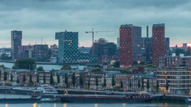 Rotterdam, Hollanda 'daki Katendrecht Yarımadası ve Maashaven Limanı' nın panoramik hava ve gece geçiş zamanı. Şehir silueti modern gökdelenler ve geleneksel Hollanda rıhtım evleri