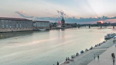 Fransa 'nın Toulouse kentindeki Garonne Nehri boyunca uzanan Port de la Daurade parkının hava görüntüsü. Gün batımında Saint-Pierre Köprüsü 'ndeki La Grave Hastanesi' nde renkli bulutlar...