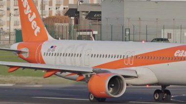 Lizbon Humberto Delgado Havalimanı 'nın pistinde farklı uçaklar hareket ediyor. Arka planda şehir manzarası ve tepeler var. Uçak taksisi, kalkış ve iniş Portekiz 'de güneşli bir günde.