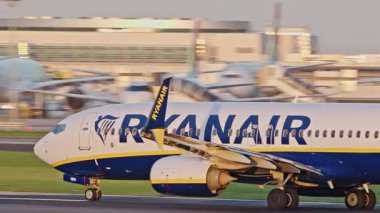 Lizbon Havaalanı 'ndan kalkış için hızlanan uçak. Ryanair uçaklarının yakın çekim görüntüleri açık gökyüzünün altında şehrin ufuk çizgisi ve havaalanı altyapısı ile pistten kalkıyor.