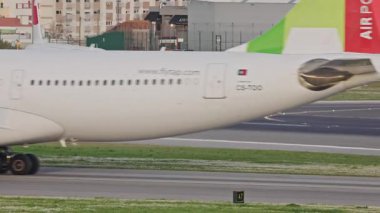 Lizbon Humberto Delgado Havaalanı 'nda arka planda tepeler ve şehir manzarası olan çeşitli uçaklar hareket halindedir. Uçak taksisi, kalkış ve iniş Portekiz 'de güneşli bir günde.