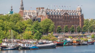 Amsterdam ufuk çizgisi Oosterdok limanındaki teknelerle Scheepvaarthuis hava zaman çizelgesi. Amsterdam Centraal İstasyonu yakınlarındaki geleneksel Hollanda mimarisi. Amsterdam, Hollanda