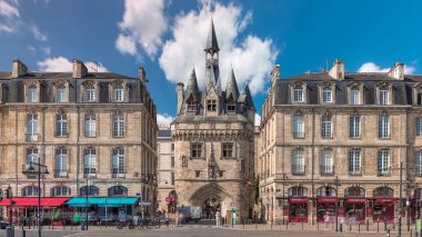 Ortaçağ mimarisi ve kuleleriyle Fransa 'nın Bordeaux kentinde tarihi Porte Cailhau zaman atlaması. Şehir manzaraları caddelerde tramvay trafiği ile birlikte geçidi ve canlı çevreyi gösteriyor.