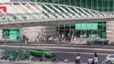 İnsanlar, Vasco da Gama alışveriş merkezinin önünden geçen bir zebrayla karşıdan karşıya geçiyorlar. Kavşakta ve bisiklet parkında trafik vardı. Lizbon, Portekiz