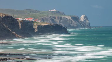 Cabo da Roca, güzel güneşli bir günde Portekiz 'in Atlantik Okyanusu' ndaki batı noktasında. Okyanus suyunun inanılmaz rengi. Magoito Sahili 'nden deniz fenerine yakın görüş