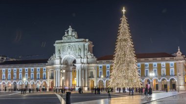 Lizbon 'daki ticaret meydanı, Noel' de yüksek bir ağaç ve geceleri kemerle aydınlandı. Dekorasyon ve tarihi mimarinin yer aldığı şenlikli atmosferin zamanlaması
