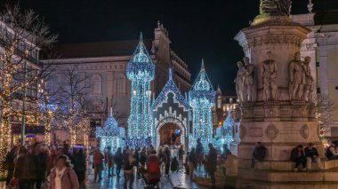 Lizbon, Portekiz 'deki Luis de Camoes meydanında aydınlatılmış şatoyla Noel süslemelerinin gece süreleri. İnsanlar festival ışıkları ve tarihi mimari etrafında yürüyorlar..
