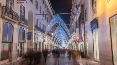 Lizbon şehir merkezindeki Chiado Carmo sokağındaki Noel ışıkları ve dekorasyonları gece aşırı hızlandı. İnsanlar aydınlanmış kemerlerin altında yürürler. Portekiz 'de festival dekorlu tatil atmosferi
