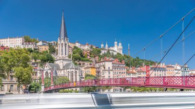 Aziz George Kilisesi, Quais de Saone ve Fourviere Bazilikası 'nın Fransa' nın Vieux Lyon kentindeki bir yaya köprüsünden hızlandırılmış zamanaşımı, tarihi mimari, yansımalar ve manzaralı nehir manzarası sergileniyor.