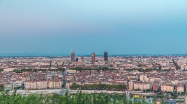Gün batımından sonra Lyon 'un panoramik hava görüntüsü Fourviere Hill' den gece dönüşümüne kadar. Ufuk çizgisinde Rhone Nehri ve sıcak bir akşamda aydınlanan ikonik kent simgeleri yer alıyor.