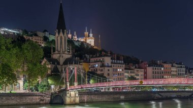 Aziz George Kilisesi, Quais de Saone ve Fourviere Bazilikası 'nın Fransa' nın Vieux Lyon kentindeki bir yaya köprüsünden hızlandırılmış zaman aşımına uğraması, geceleri tarihi mimari, yansımalar ve manzaralı nehir manzarası sergilenmektedir.