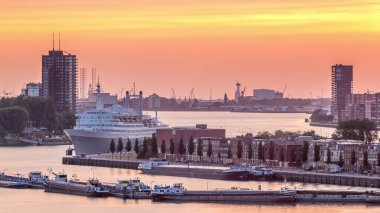 Hollanda 'nın Rotterdam şehrinde gün batımında Maashaven Limanı' nın hava zamanı. Rıhtımın ufuk çizgisi ve eski bir yolcu gemisi olan SS Rotterdam, şimdi Katendrecht 'e demirlemiş bir otel.