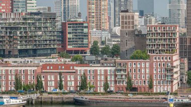 Rotterdam şehir merkezi, Hollanda 'daki modern binaların uçuş zamanı. Finans bölgesindeki kuleler ve gökdelenler sabah sıcacık ışıklarıyla canlı bir ufuk çizgisi oluşturuyor. Rıhtımdaki gemiler