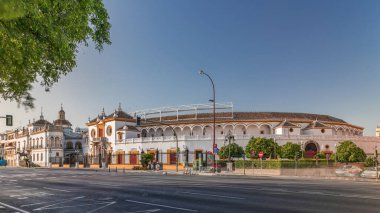 Plaza de Toros de la Real Maestranza de Caballeria de Sevilla zaman atlaması. İspanya 'nın Seville şehrinde boğa güreşi festivalleriyle tanınan tarihi boğa güreşi. Trafik ön cephesinin önünden geçiyor.