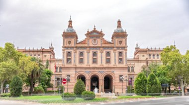 İspanya, Seville 'deki 2. Askeri Bölgenin Kaptanlığı cephesi. Endülüs 'teki Kara Kuvvetleri Karargahı. Trafik, bulutlu gökyüzü ve yeşil ağaçlarla hızlandırılmış zaman aşımı.