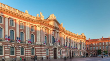 Capitole de Toulouse zaman ayarlı hiperlapse gösterilerinde Fransa 'nın Toulouse şehrinin tarihi belediye binası ve belediye kalbi mavi gökyüzünün altında yer alır. Gün batımında gölge kaplaması