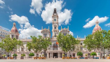 Valencia Belediye Binası (Ajuntament de Valencia) Plaza de Ayuntamiento 'da zamanaşımına uğradı. Mavi bulutlu gökyüzünün altında saat kulesi olan tarihi bir bina. İspanya 'nın ana meydanında gezinen insanlar