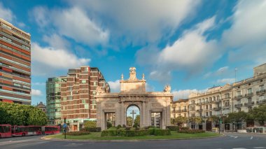 İspanya, Valencia 'da La Porta de la Mar zaman atlaması. Bir zamanlar ortaçağ duvarlarının bir parçası olan bu neoklasik kapı kalabalık bir kavşağın üzerinde duruyor. Gün batımında parlak bir gökyüzünün altında değerli bir şehir simgesi.