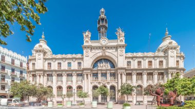 Belediye Binası Meydanı 'nda (Plaza del Ayuntamiento Meydanı) tarihi Posta Ofisi' ni (Palau de les Comunicacions) gösteren panorama. Süslü cephe, trafik ve İspanya şehir merkezinde mavi bir gökyüzü..
