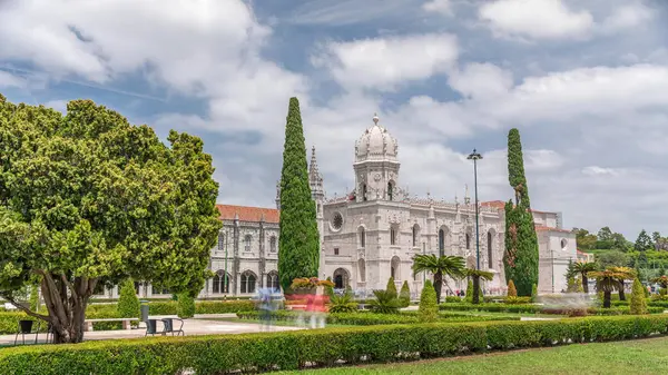 Mosteiro dos Jeronimos ve bahçede çimenliği olan yeşil ağaçlar, Lizbon, Portekiz 'in Belem bölgesinin zaman diliminde yer almaktadır. Manueline tarzı (Portekizce geç Gotik). Mavi gökyüzünde bulutlar