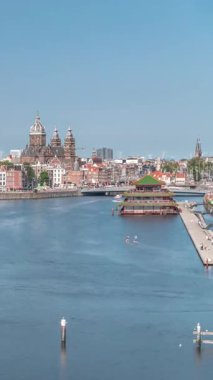 Sudaki pagoda biçiminde bir Çin restoranının hava manzarası, tarihi şehir merkezi binalarının ve nehir kıyısındaki yüzen teknelerin zeminine karşı kurulur. Amsterdam, Hollanda