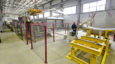 Operatör kaldırma cihazı panoramik zaman ayarlı, kaldırma mıknatısı, mekanik atölye, beton ve metal yapılar fabrikası kullanarak yükleri kaldırıyor. Güçlendirilmiş beton Fabrikası Modern Atölyesi