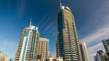 Dubai Marina modern uzun kuleleri, Birleşik Arap Emirlikleri 'ndeki gezinti zamanlarından suya yansıdı. Dubai 'de bir bölge ve yapay bir kanal. Mavi bulutlu gökyüzü