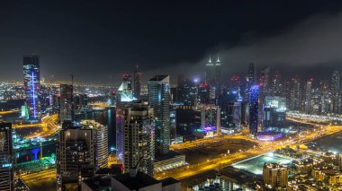 Gece vakti büyük, modern bir şehrin havadan görünüşü gece trafiği, aydınlık gökdelenler, ofis binaları. İş Körfezi, Dubai, Birleşik Arap Emirlikleri.