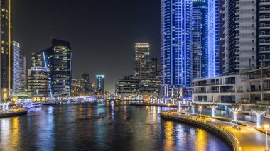 Dubai Marina 'da yatları ve Dubai' deki köprüden restoranları olan modern kuleleri olan bir gezinti alanı, Birleşik Arap Emirlikleri. Yapay kanalla aydınlatılmış bölge