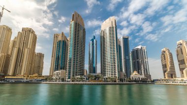 Dubai Marina modern kuleleri yüzen yatları ve gezinti güvertesinden botları olan Birleşik Arap Emirlikleri. Gökdelenlerin en yükseği. Mavi bulutlu gökyüzü