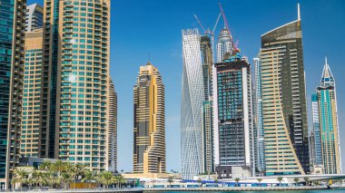 Dubai Marina modern kuleleri yüzen yatları ve gezinti güvertesinden botları olan Birleşik Arap Emirlikleri. Gökdelenlerin en yükseği. Mavi bulutlu gökyüzü