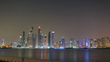 Dubai Marina silueti, Dubai, BAE 'deki Palm Jumeirah' dan görüldüğü gibi JBR 'den geceye geçiş zamanı panoraması. Dubai 'nin bu kısmında 50 kattan fazla gökdelen var.