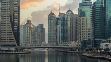 Dubai Marina Kanalı 'nın sabah manzarası, modern kuleleri ve yatlarıyla Dubai' deki köprüden yansıyan güneş doğumu saati, Birleşik Arap Emirlikleri.