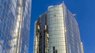 Panoramik ve perspektiften çelik camlı gökdelenlere zaman ayarlı, başarılı endüstriyel mimari konsepti Dubai, BAE 'ye bakın. Güneşli bir günde mavi bulutlu gökyüzü