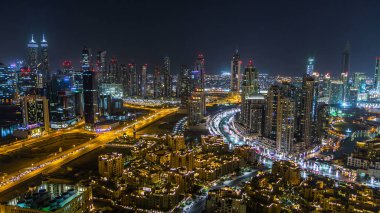 Gece vakti büyük, modern bir şehrin havadan görünüşü gece trafiği, aydınlık gökdelenler, ofis binaları. İş Körfezi, Dubai, Birleşik Arap Emirlikleri.
